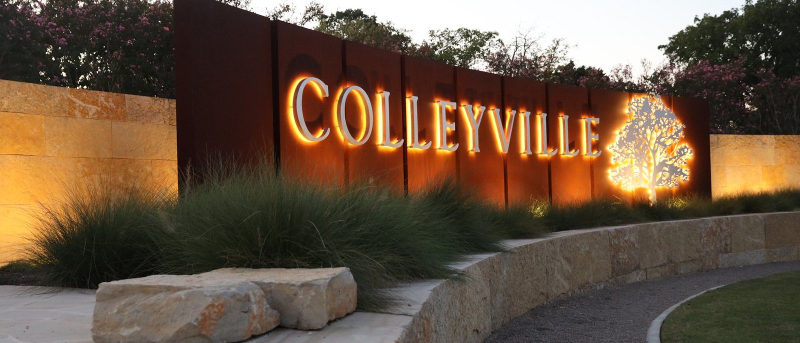 The Colleyville gateway sign glowing at dusk
